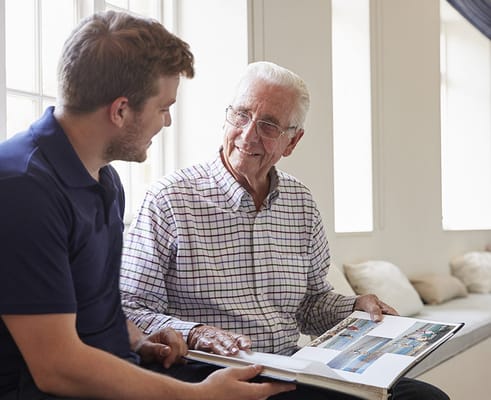 Resident and staff member looking at a photo album