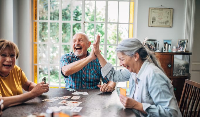 Residents enjoying a card game in a common area