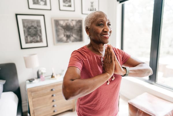 Senior woman practicing yoga in a bright room