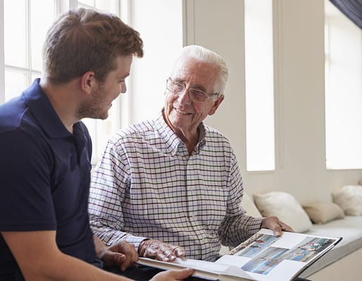 A resident and staff member looking at a photo book
