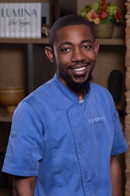 Staff member in a kitchen setting with a welcoming smile