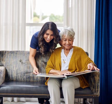 Staff member assisting a resident with a book