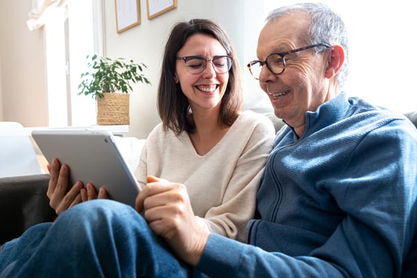 A resident and staff member enjoying time together with a tablet