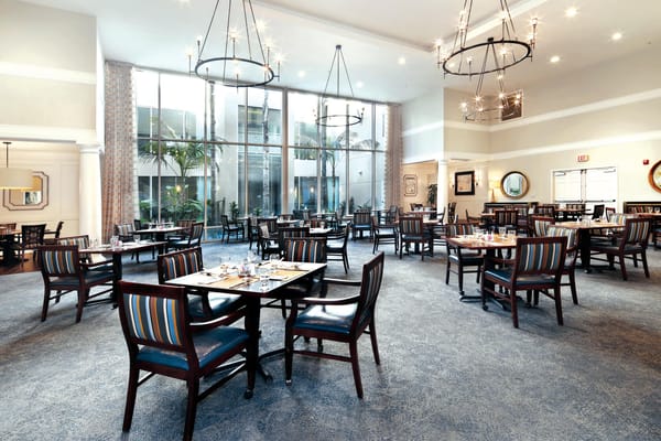 Bright dining room with tables and chairs set for meals