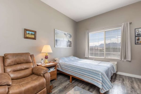 Cozy resident room with a bed and armchair