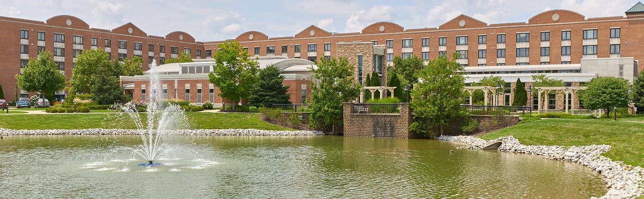 Exterior view of Marquette Senior Living with landscaped pond