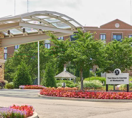 Well-maintained entrance with flowers and signage at the facility