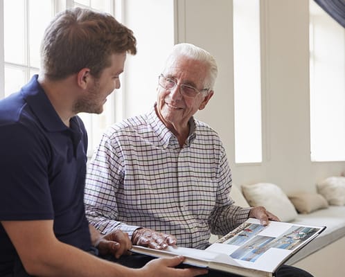Resident engaging with staff while looking at a photo album