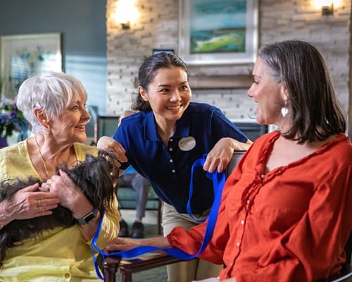 Residents and staff interacting with a small dog