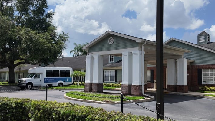 Building entrance with a shuttle bus parked outside