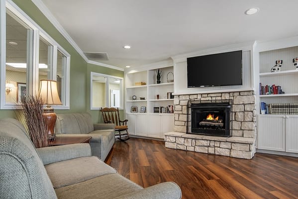 Cozy lounge area with a fireplace and bookshelf