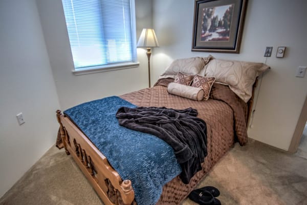 Cozy bedroom with a bed, blankets, and lamp