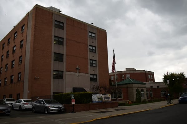 Exterior view of a senior living facility with flag