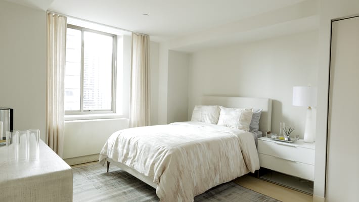 Bright, well-furnished private resident room with a bed and window