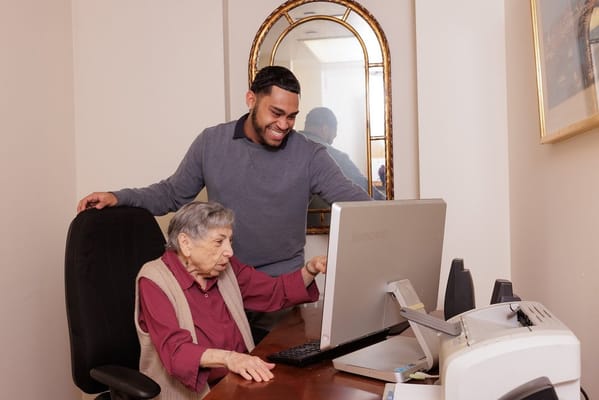 Staff member assisting resident at a computer