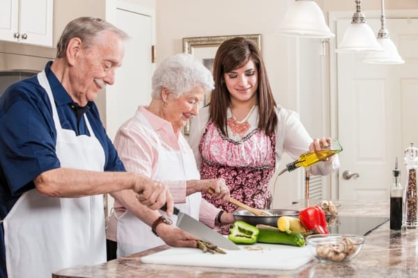 Residents and staff cooking together in a kitchen