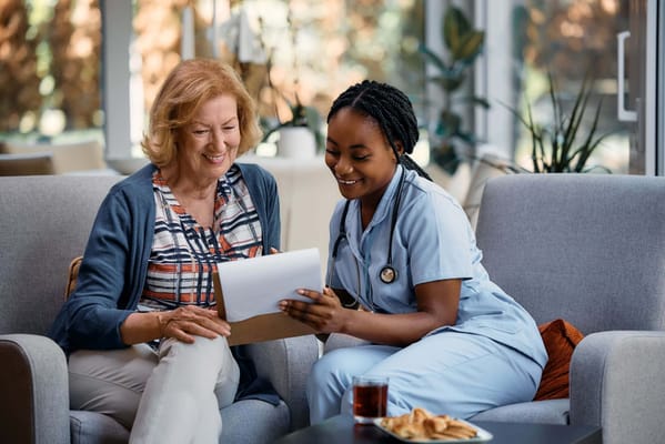 Resident and caregiver discussing in a cozy lounge