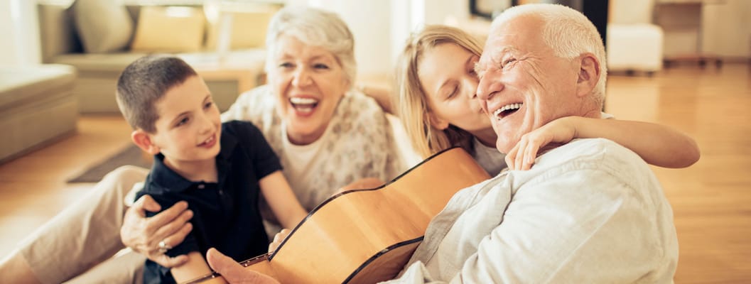 Seniors enjoying music with children in a warm interior space