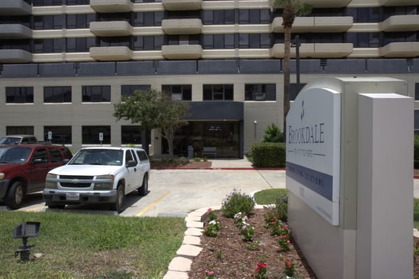 Exterior view of Brookdale Trinity Towers with parking area