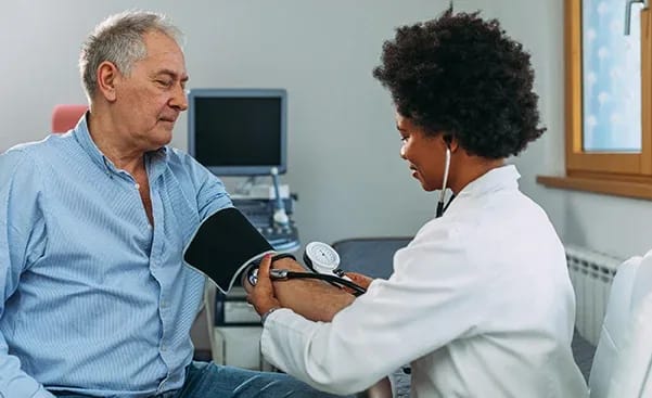 Healthcare professional checking blood pressure of a senior resident