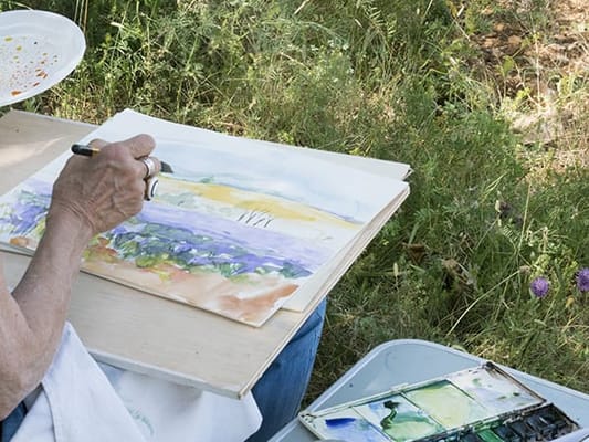 Resident painting in a garden setting