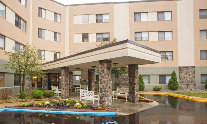 Entrance of Brookdale Echelon Lake with seating and landscaping