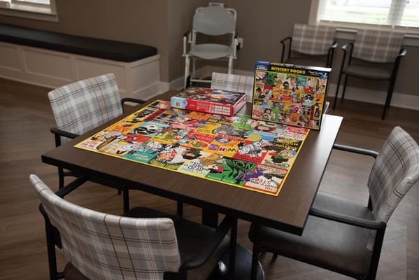 Table with a colorful puzzle and board games in an activity room