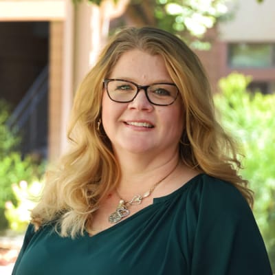 Staff member smiling in a garden area