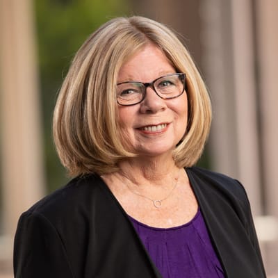 Portrait of a smiling senior woman in a purple blouse