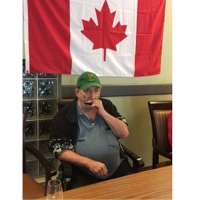 Resident playing harmonica under a Canadian flag