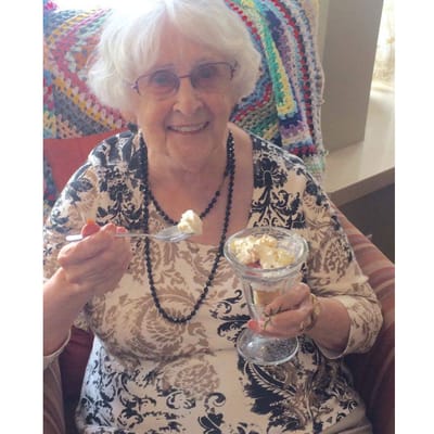 Resident enjoying a dessert with a smile