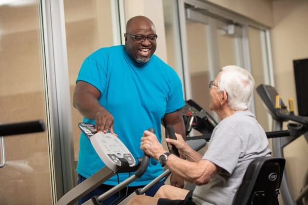 Staff assisting an elderly resident in the gym