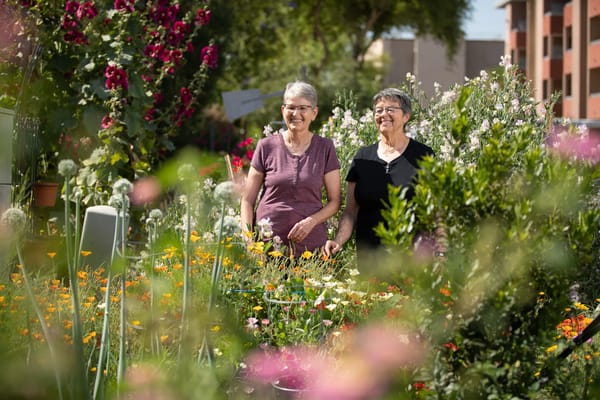 Two residents enjoying a vibrant community garden