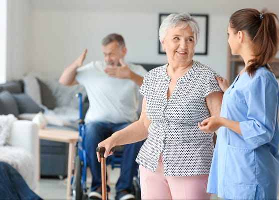 An elderly woman interacting with a caregiver in a living space