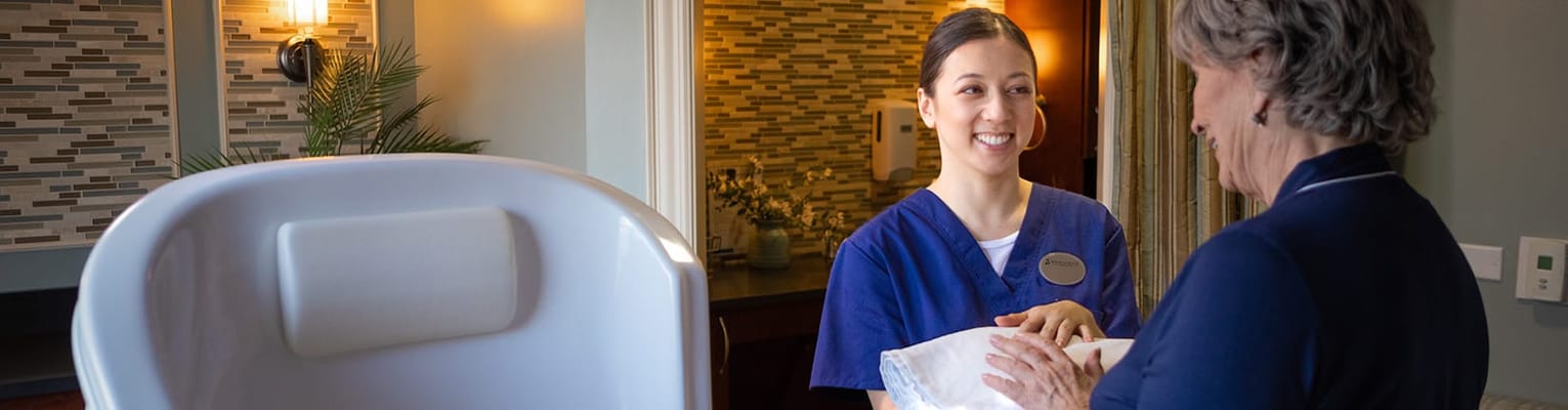 Staff member assisting a resident in an interior setting