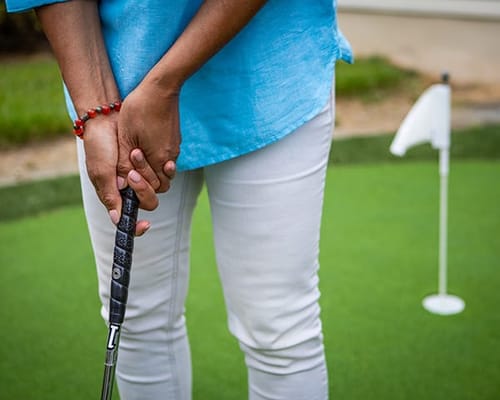 A person preparing to putt on a putting green