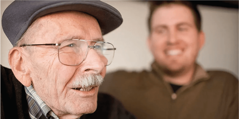 Elderly man smiling with a younger companion
