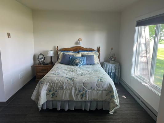 Comfortable bedroom featuring a bed, nightstand, and natural light