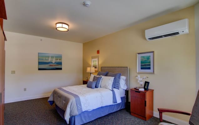 Brightly decorated resident room with a bed and art