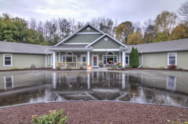 Front view of Azura Memory Care facility with puddles reflecting the building.