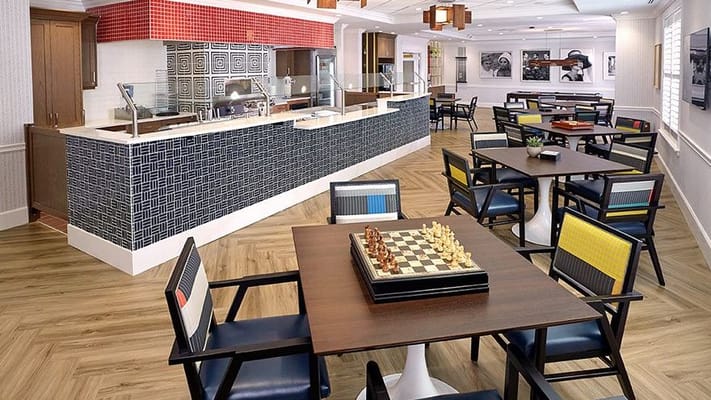 Well-lit dining area with chairs and chess set