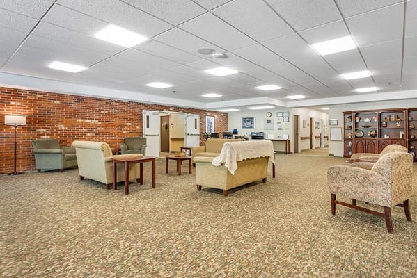 Bright common area with seating and carpeted flooring
