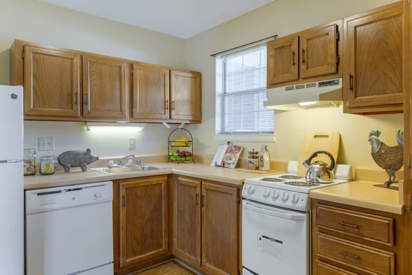 Bright kitchen area with wooden cabinets and appliances