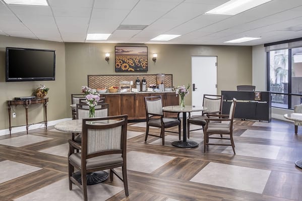 Bright common area with seating, TV, and refreshments
