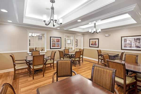 Brightly lit dining room with wooden tables and chairs