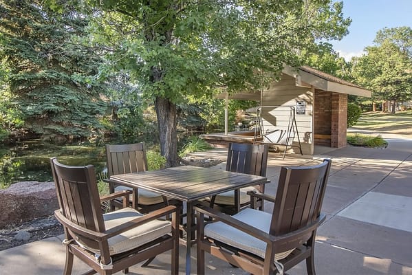 Outdoor seating area with a pond and trees