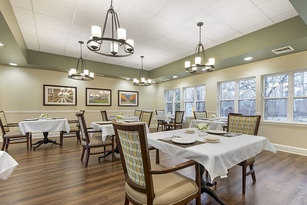 Well-lit dining room with tables set for meals