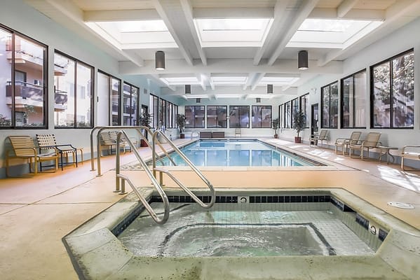Indoor pool area with seating and natural light