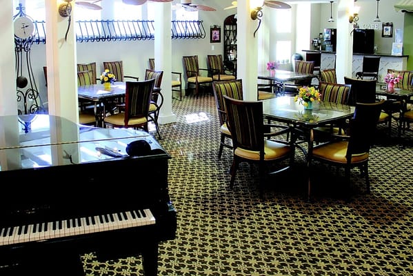 Interior view of a common area with tables and a piano