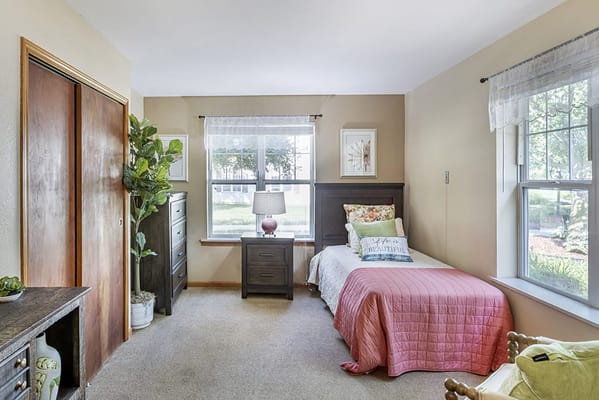 Brightly lit private resident room with decor